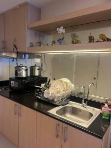 - un comptoir de cuisine avec évier et four micro-ondes dans l'établissement SMDC FORT TAGAYTAY STAYCATION, à Kaybagal