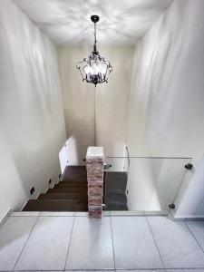 een kamer met een kroonluchter en een trap met een tafel bij Casa Madero in Ciudad Madero