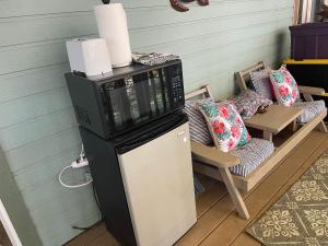 a microwave sitting on top of a refrigerator next to a chair at Her Castle Bed and Breakfast in Cambria