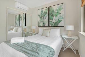 a bedroom with a bed and two tables with lamps at Whitfield Waters - Resort Living for Families in Edge Hill +25 photos