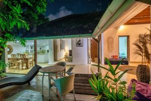 a house with a patio with chairs and a table at Legian Beach 3 Bedroom Villa in Legian