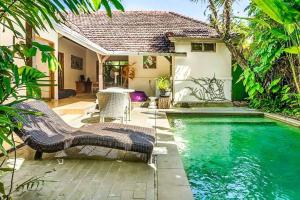 a house with a pool and a table and chairs at Legian Beach 3 Bedroom Villa in Legian
