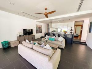 a living room with couches and a ceiling fan at AP Natai Luxury Beachfront Pool Villas in Phang-nga