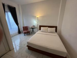 1 dormitorio con 1 cama, 1 silla y 1 ventana en Rayana Resort Mitra Reddoorz, en Songgoriti