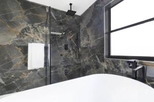 W łazience znajduje się prysznic i lustro. w obiekcie Modern Lakefront Home w mieście Wellington