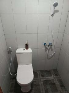 a bathroom with a white toilet and a shower at Aquila Family Homestay in Lampung