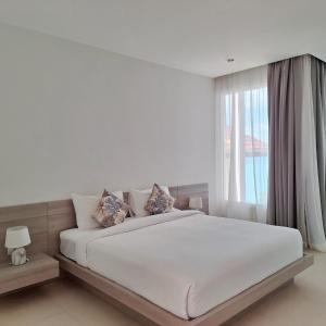 a white bedroom with a large bed with a window at Baanfah Resort Samui in Mae Nam +57 photos