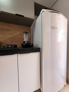 a kitchen with a white refrigerator next to a counter at Cozy Studio in Intermares in Ilha da Restinga +28 photos