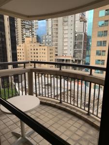 a balcony with a bench and a view of a city at Flat Espaço Itaim BIBI I in Sao Paulo