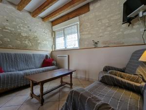 ein Wohnzimmer mit einem Sofa und einem Tisch in der Unterkunft Gîte Frédille, 4 pièces, 6 personnes - FR-1-591-217 