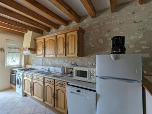 eine Küche mit einem weißen Kühlschrank und einer Mikrowelle in der Unterkunft Gîte Frédille, 4 pièces, 6 personnes - FR-1-591-217 