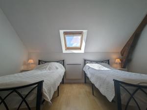 zwei Betten in einem Zimmer mit Fenster in der Unterkunft Maison au cœur du Berry : tranquillité, jeux pour enfants et proche Château de Valençay et Zoo de Beauval - FR-1-591-235 in Frédillé