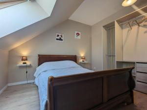 ein Schlafzimmer mit einem Bett und zwei Lampen im Dachgeschoss in der Unterkunft Gîte Frédille, 3 pièces, 4 personnes - FR-1-591-235 