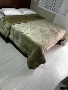 a bed in a bedroom with a blanket on the floor at Loft Lux 7 in Chapecó