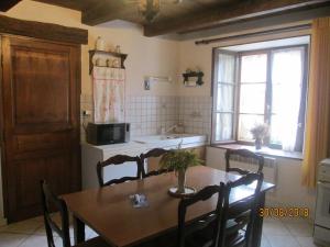 a kitchen with a dining room table and a table and chairs at Maison cosy avec terrasse, 3 chambres, wifi, animaux acceptés, idéal pour familles en Meuse - FR-1-585-2 in Bréhéville +13 photos