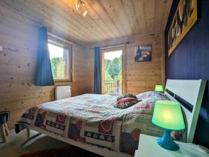 1 dormitorio con 1 cama en una cabaña de madera en Gîte La Bresse, 3 pièces, 4 personnes - FR-1-589-264, en La Bresse