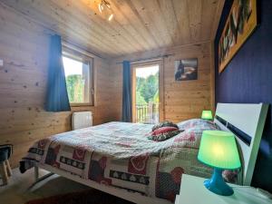 um quarto com uma cama num chalé de madeira em Gîte La Bresse, 3 pièces, 4 personnes - FR-1-589-264 em La Bresse