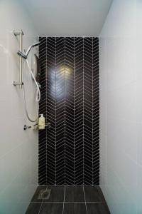 uma casa de banho com um chuveiro com azulejos pretos e brancos em Ben Cozy Executive Suite 3BR The Horizon Ipoh em Ipoh