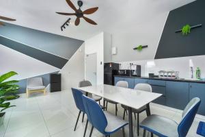 uma cozinha com uma mesa branca e cadeiras azuis em Ben Cozy Executive Suite 3BR The Horizon Ipoh em Ipoh