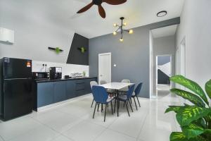 a kitchen with a dining table and blue chairs at Ben Cozy Executive Suite 3BR The Horizon Ipoh in Ipoh +10 photos