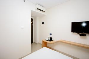 a room with a flat screen tv on a wall at Zodiak Asia Afrika by KAGUM Hotels in Bandung