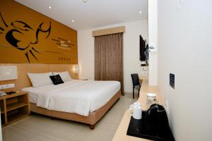 a hotel room with a bed and a desk at Zodiak Asia Afrika by KAGUM Hotels in Bandung