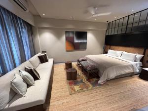 ein Schlafzimmer mit einem Bett und einem Sofa in der Unterkunft Soul Nest-Pyramid Valley International Bengaluru in Hārohalli