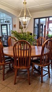 uma mesa de jantar em madeira com cadeiras e um lustre em Guest Haven Chalet em Baguio