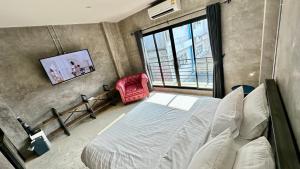 - une chambre avec un lit et une télévision murale dans l'établissement Norn Nee Nor, à Chiang Mai