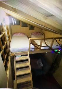 Habitación pequeña con 2 literas y escalera. en Cabaña bosque, en Recinto