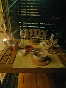 una mesa de madera con tazones y copas de vino. en CasaMar ElQuisco, en El Quisco
