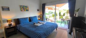 a bedroom with a bed with a blue comforter at Yawee Homestay in Ban Phe