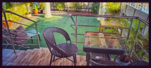 班菲的住宿－Yawee & Jo Guesthouse，阳台配有两把椅子和一张玻璃桌