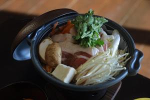 uma tigela de comida com noodles e outros vegetais em Kutsurogian em Minami Uonuma