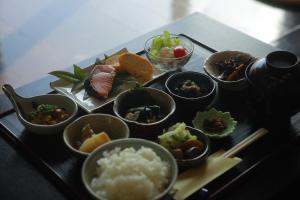 uma bandeja de comida com tigelas de comida numa mesa em Kutsurogian em Minami Uonuma