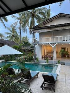 White Coconut Resort في غيلي تراوانغان: منزل بمسبح بجوار منزل