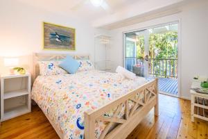 a bedroom with a bed and a large window at Treetops in Pearl Beach