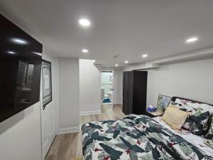 a bedroom with a bed and a flat screen tv at One Bedroom Apartment in Ajax