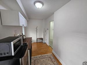 a kitchen with a microwave on a counter in a room at One Bedroom Apartment in Ajax