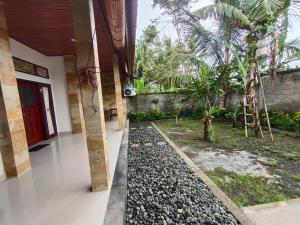 a building with a walkway in front of a garden at Molog guest house in Ubud