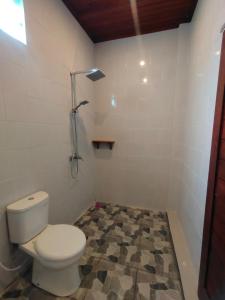 a bathroom with a toilet and a shower at Molog guest house in Ubud
