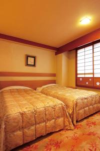 a bedroom with two beds and a window at Kinugawa Park Hotels in Nikko