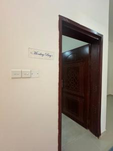 a wooden door with a mirror in a room at Maison Masirah in Şūr Maşīrah