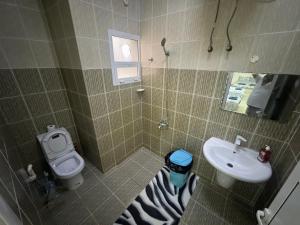 a bathroom with a sink and a toilet at Maison Masirah in Şūr Maşīrah