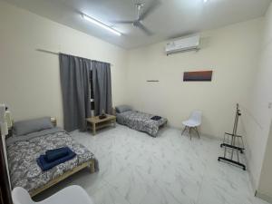 um quarto com 2 camas e um quarto com uma câmara em Maison Masirah em Şūr Maşīrah