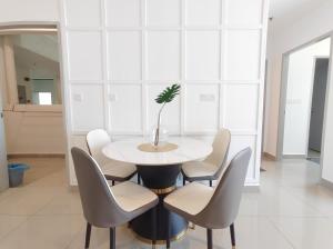 a dining room with a white table and chairs at Amber Cove - Luxury Design By Luxpro Management - 6~7 pax in Malacca