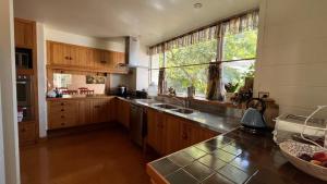 a kitchen with wooden cabinets and a large window at Father House in Kaiapoi
