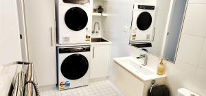 a small bathroom with a washing machine and a sink at NYC Loft Brisbane, Free Parking! in Brisbane +16 photos