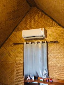 um purificador de ar pendurado numa parede ao lado de uma cortina em Pai Kitchen Hub Hostel em Pai