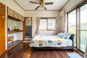a bedroom with a bed and a ceiling fan at Beach House Yomitan in Yomitan